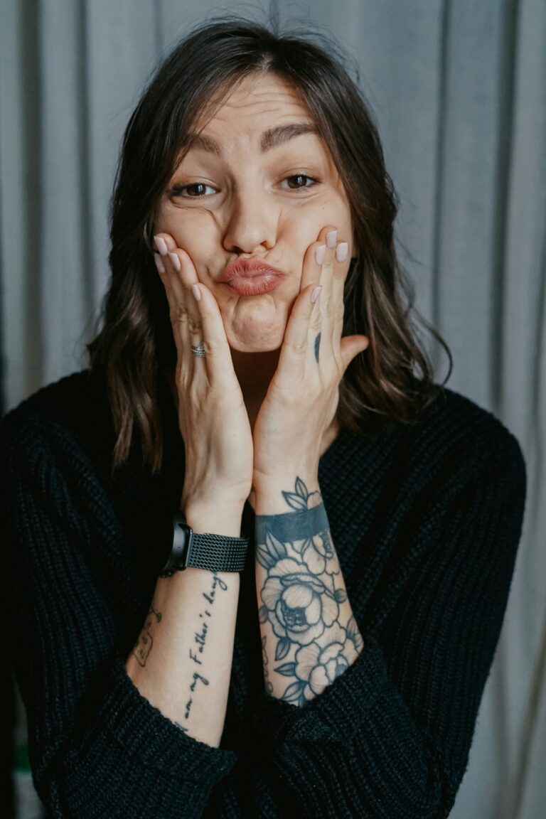 Person pressing both hands to their cheeks, letting an emotion show instead of holding it in