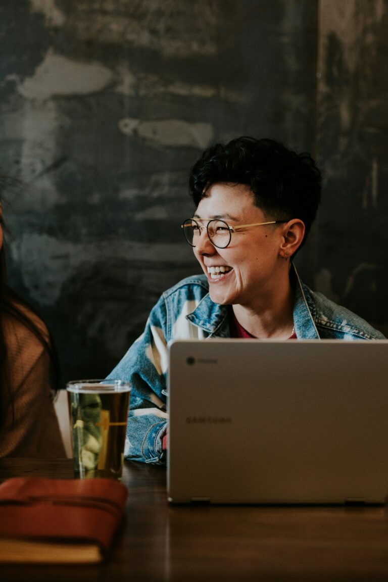 Person laughing during an online Emotion Awareness and Expression Therapy session on a laptop